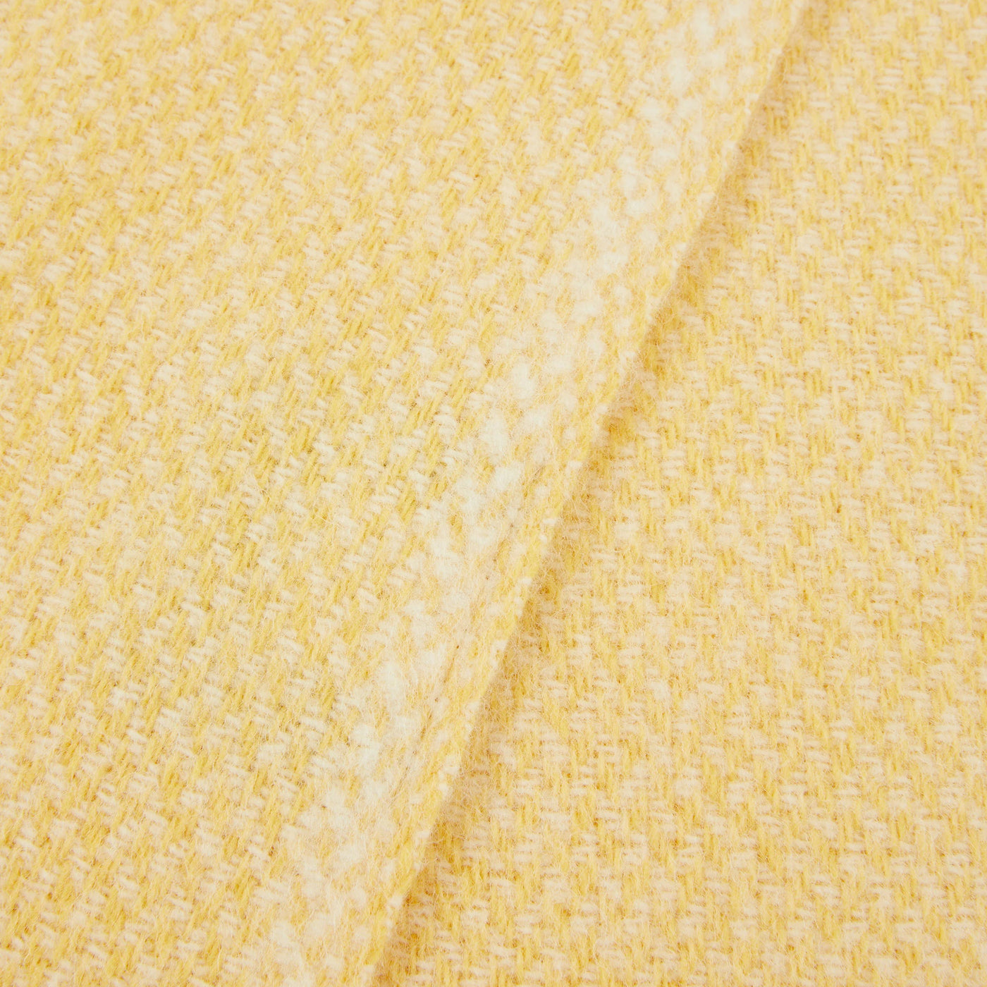 Close-up of Lanerossi Northland throw in butter yellow, showing woven wool texture and folded edge.