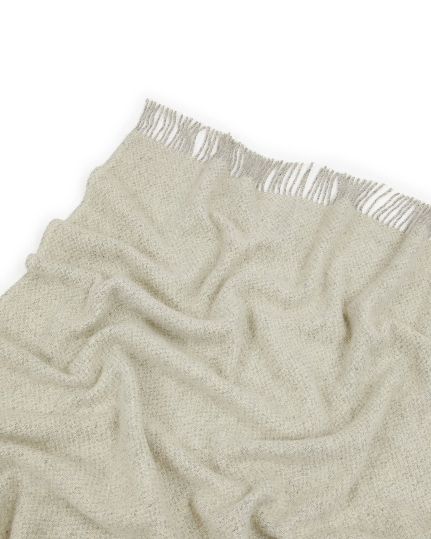 Close-up of Lanerossi Northland throw fringe edge, sage boucle weave with white fringe trim.