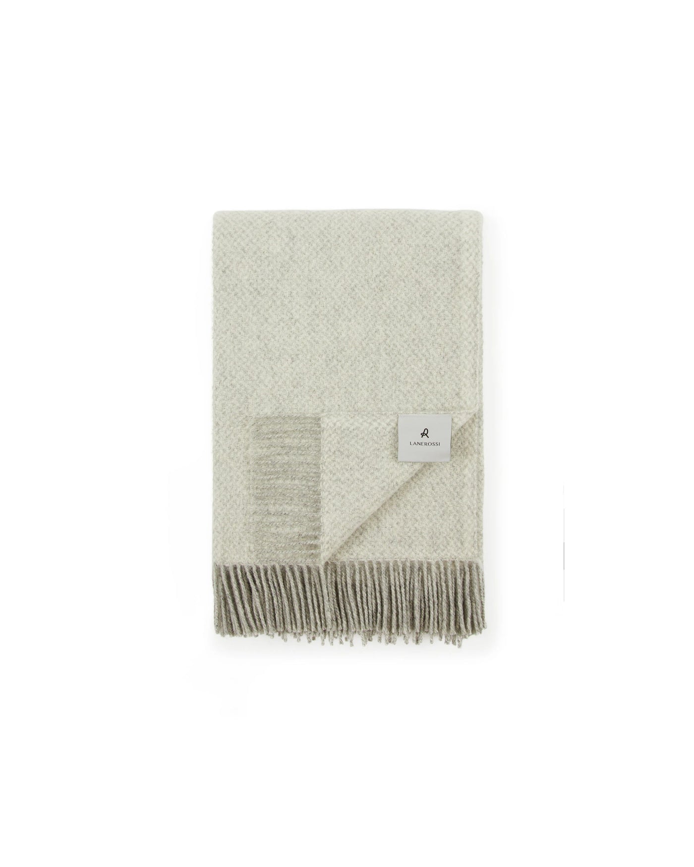 Folded ivory Lanerossi Northland throw with diamond weave texture and taupe fringe trim.
