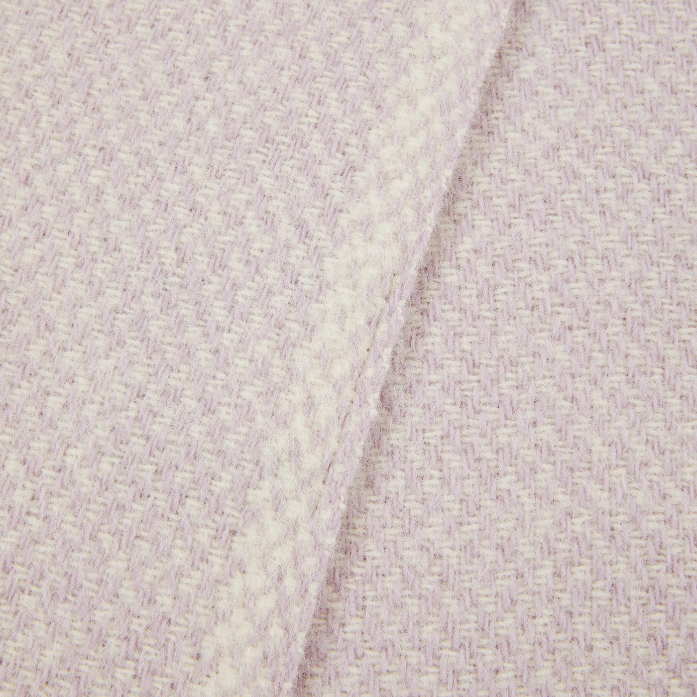 Close-up of Lanerossi Northland throw in blush, showing woven basket-weave texture and folded edge.