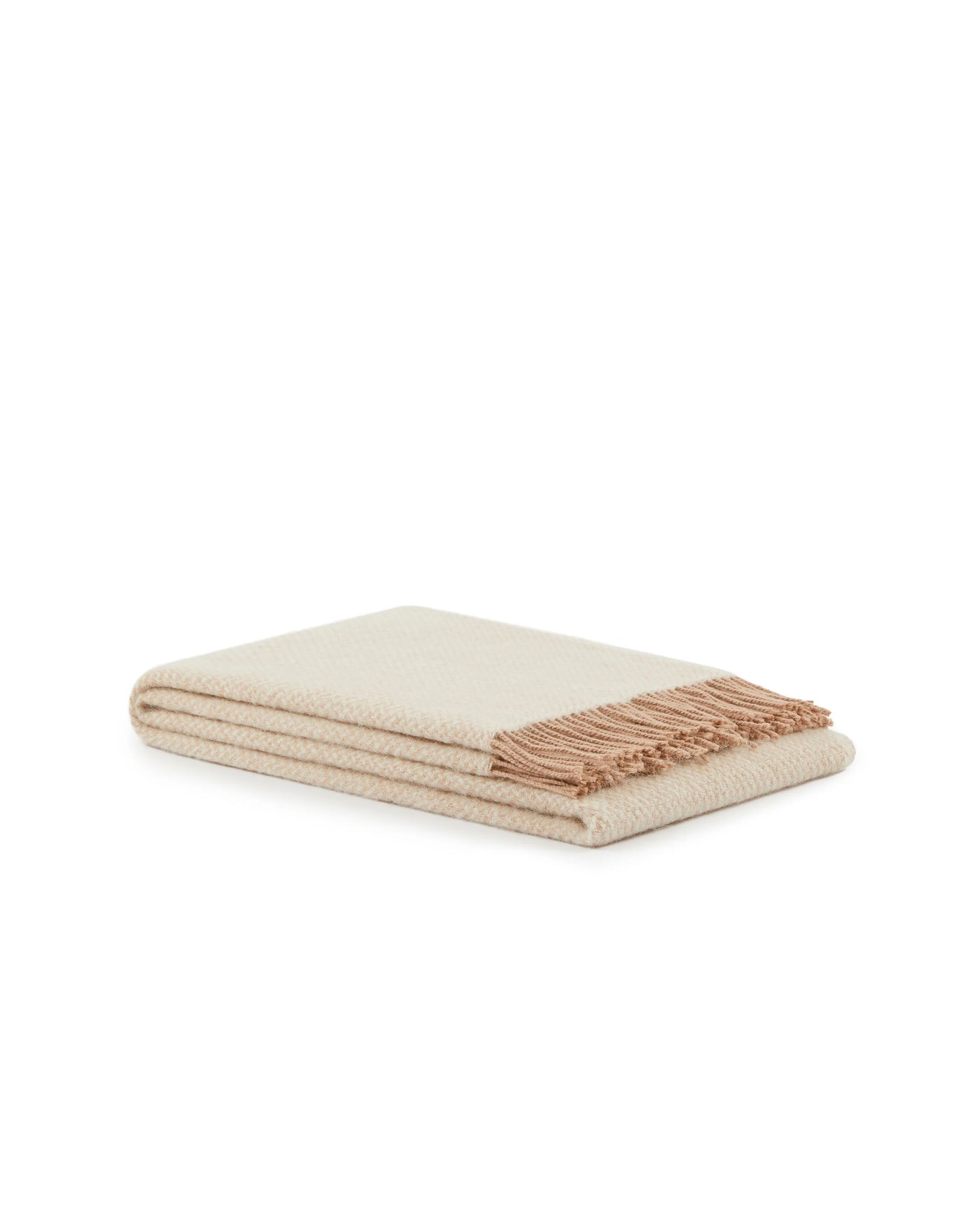 Folded ivory throw with blush fringe trim and subtle woven texture, angled view.