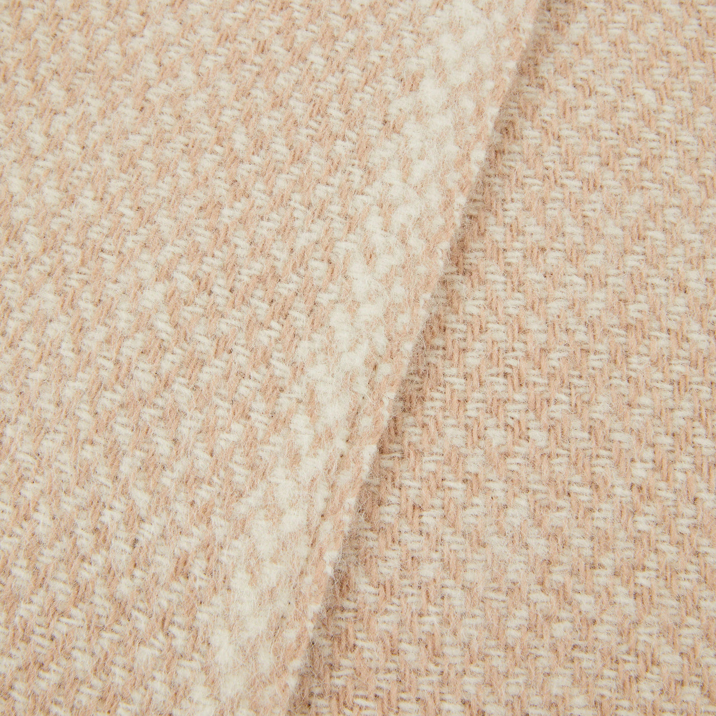 Close-up of Lanerossi Northland throw's blush and ivory woven texture, folded edge visible.