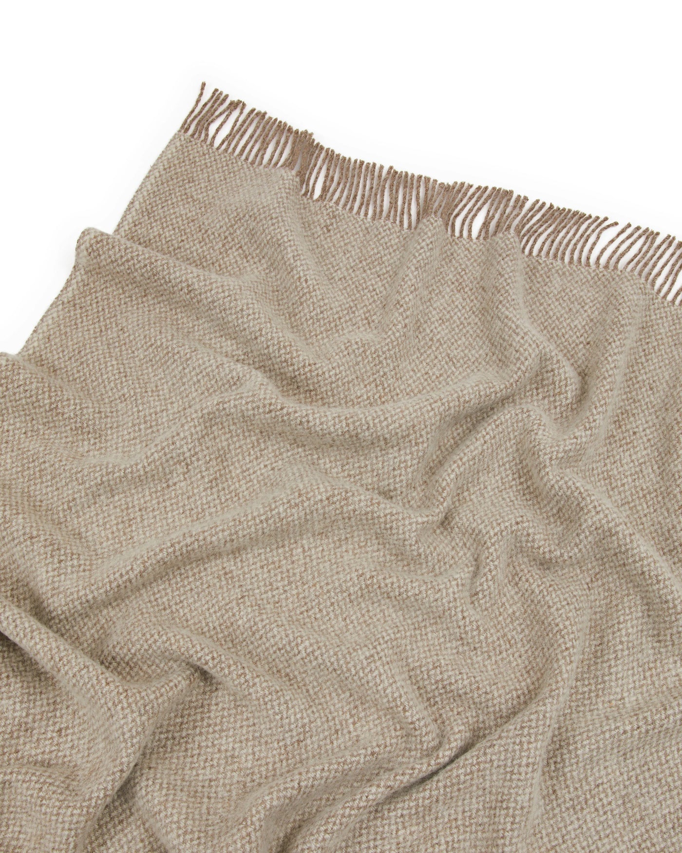 Close-up of Lanerossi Northland throw in sand, showing woven texture and knotted fringe edge.