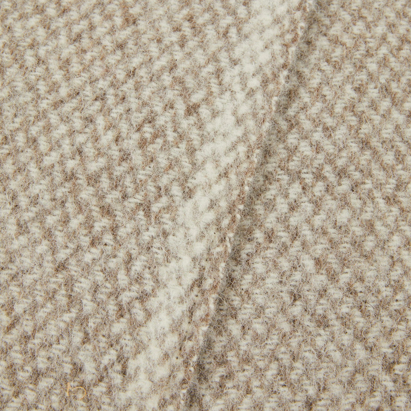 Close-up of Lanerossi Northland throw's ivory and camel woven wool texture with diagonal drape.