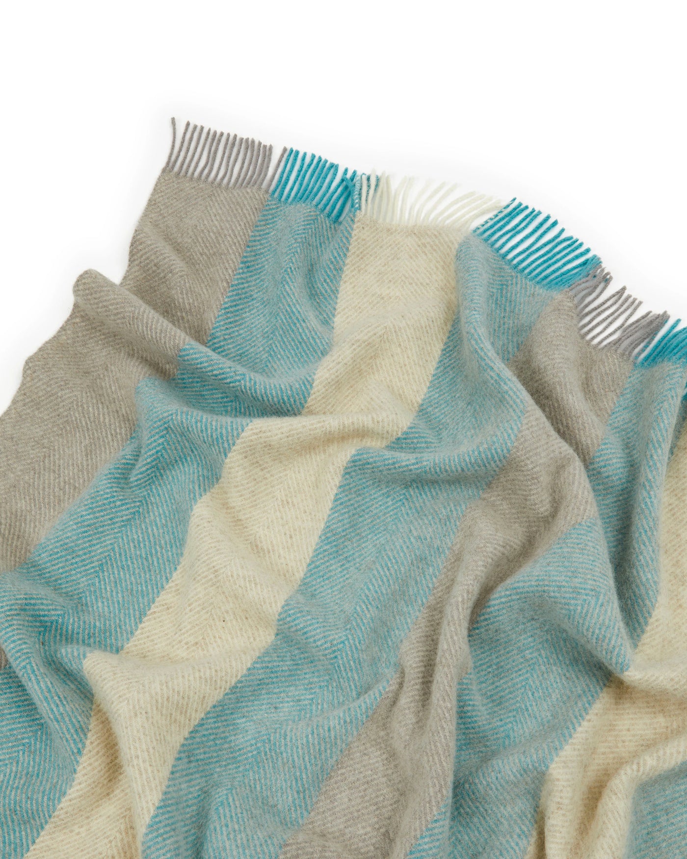 Close-up of Lanerossi Opua throw's fringe edge, teal, taupe, and ivory wide stripes.