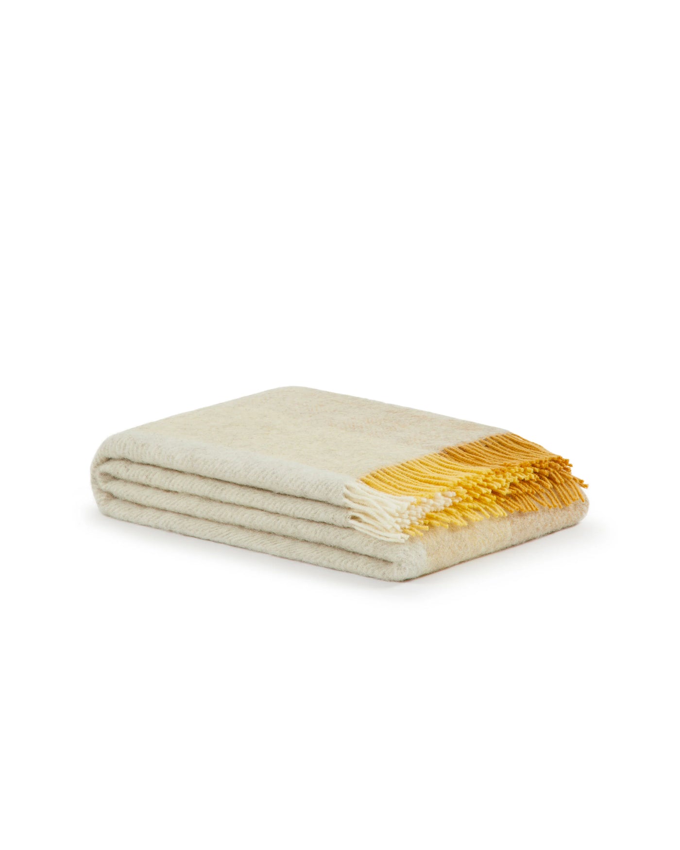 Folded ivory throw with bright saffron fringe detail at corner.