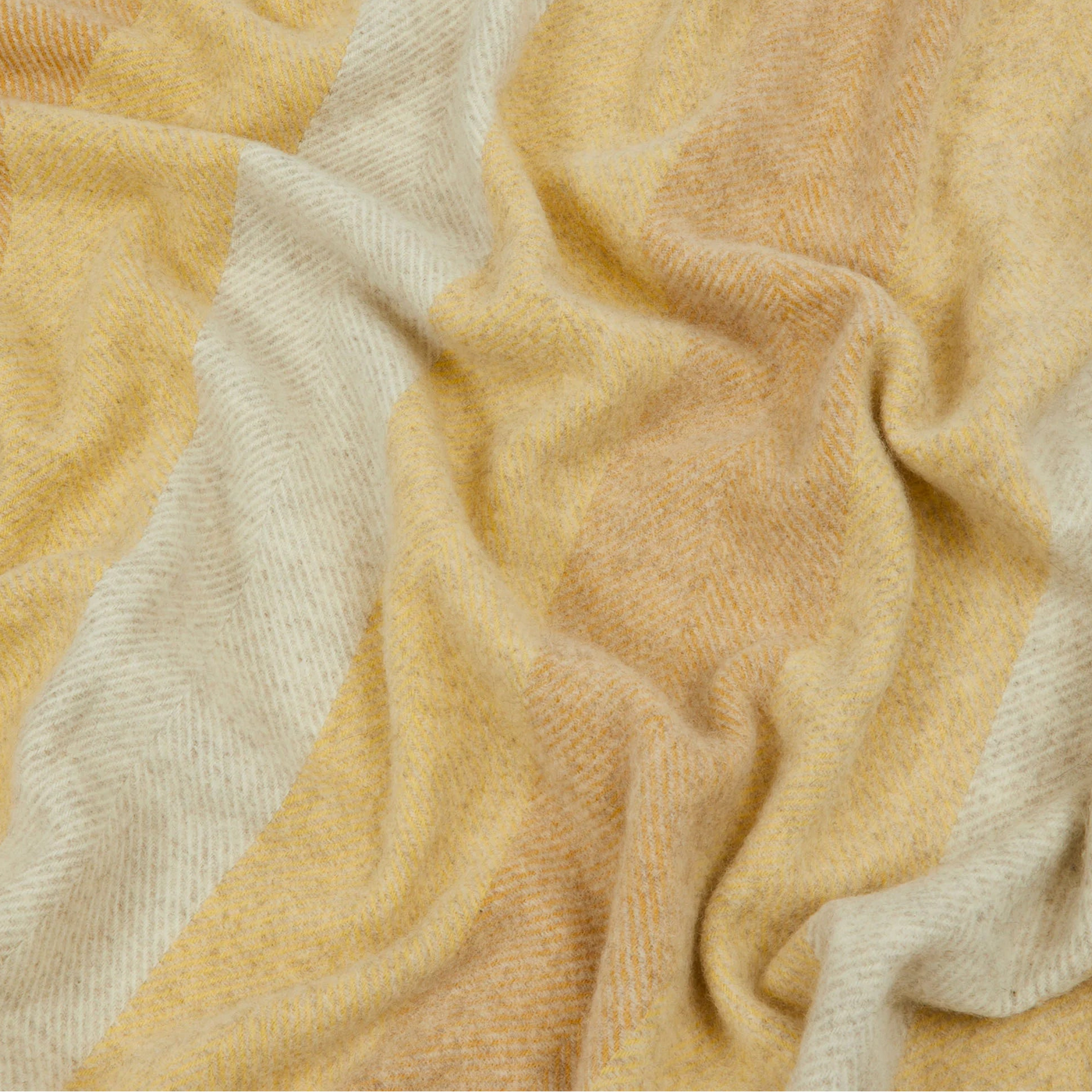 Close-up of Lanerossi Opua throw in honey and ivory herringbone weave, softly draped.