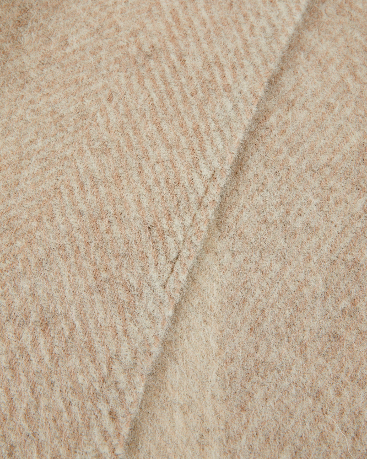 Close-up of Lanerossi Opua throw showing ivory herringbone weave texture and folded edge.