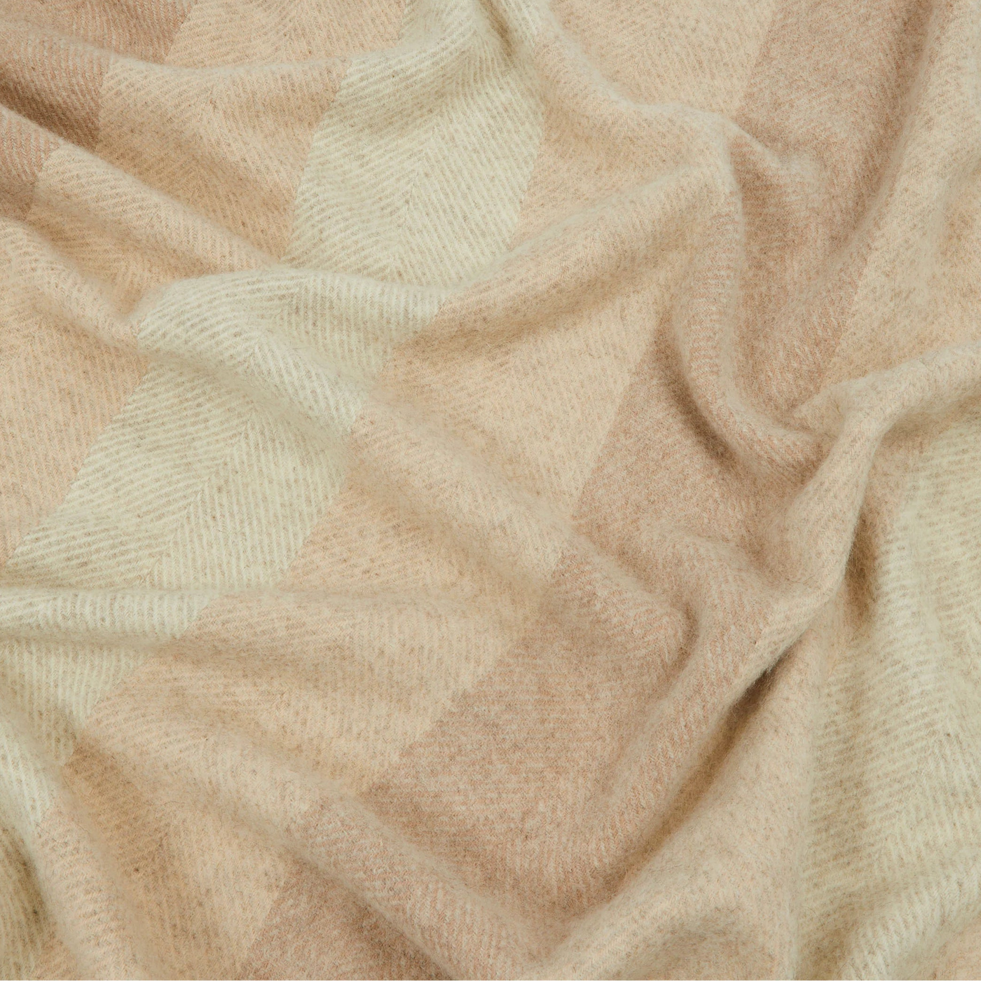 Close-up of Lanerossi Opua throw in camel and ivory herringbone block pattern.