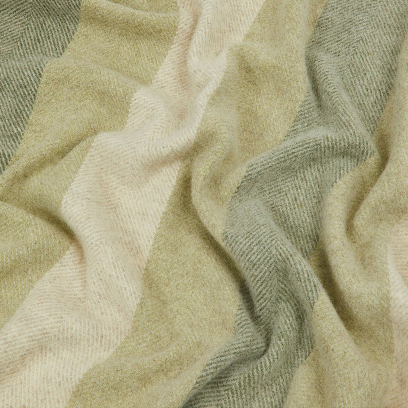 Close-up of Lanerossi Opua throw's herringbone weave in sage and ivory stripe detail.