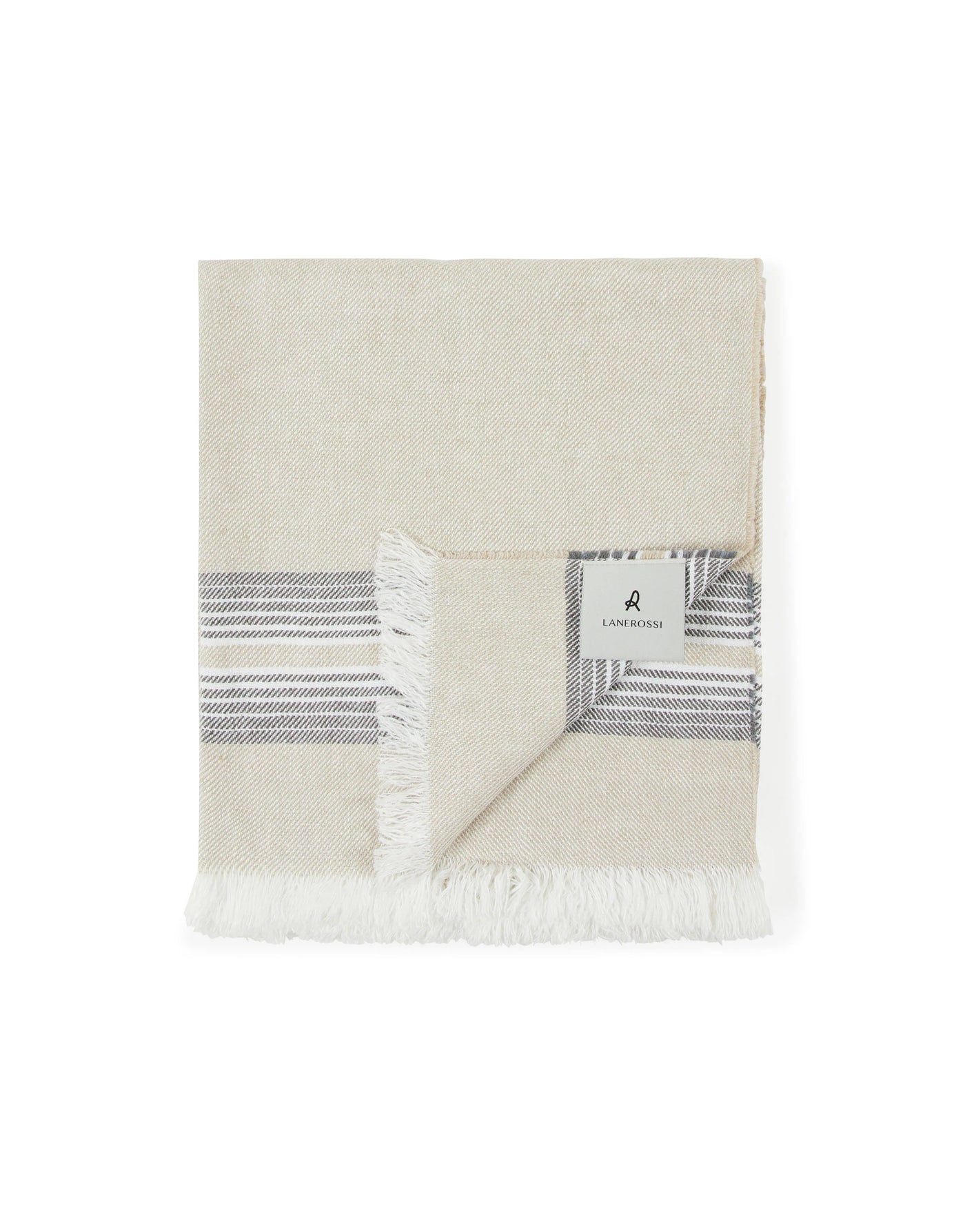 Close-up of folded Palau throw corner showing charcoal stripe border and fringe detail.