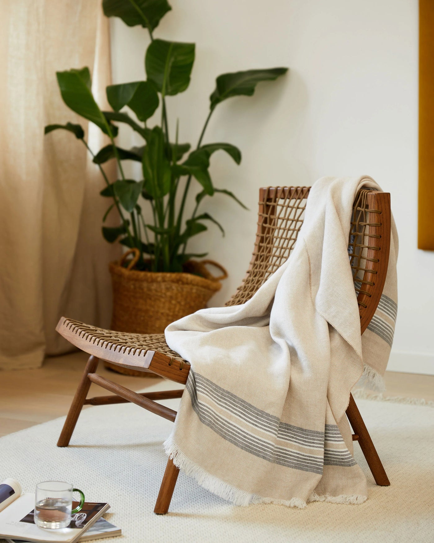 Lanerossi Palau throw draped over wicker chair, ivory with slate blue stripes and fringe trim.