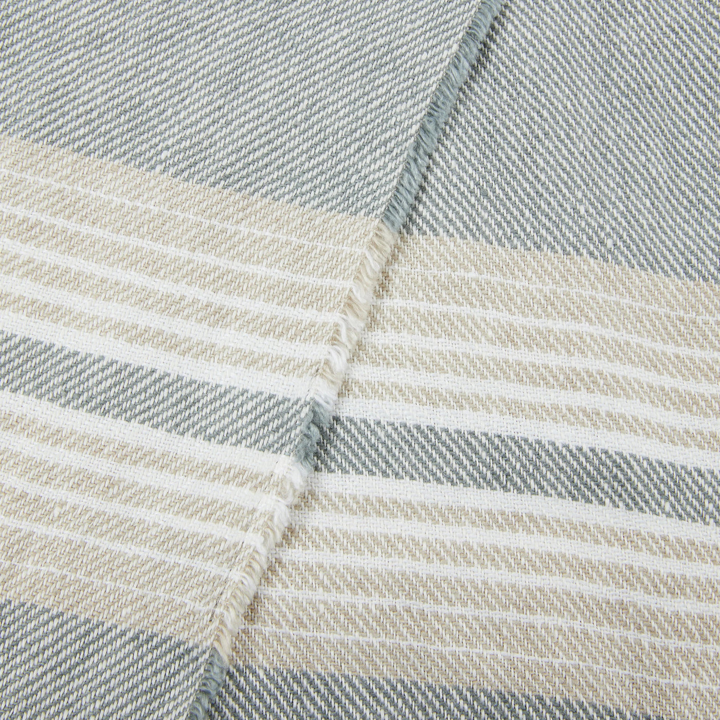 Close-up of Lanerossi Palau throw showing slate and sand multi-stripe weave with folded hem detail.