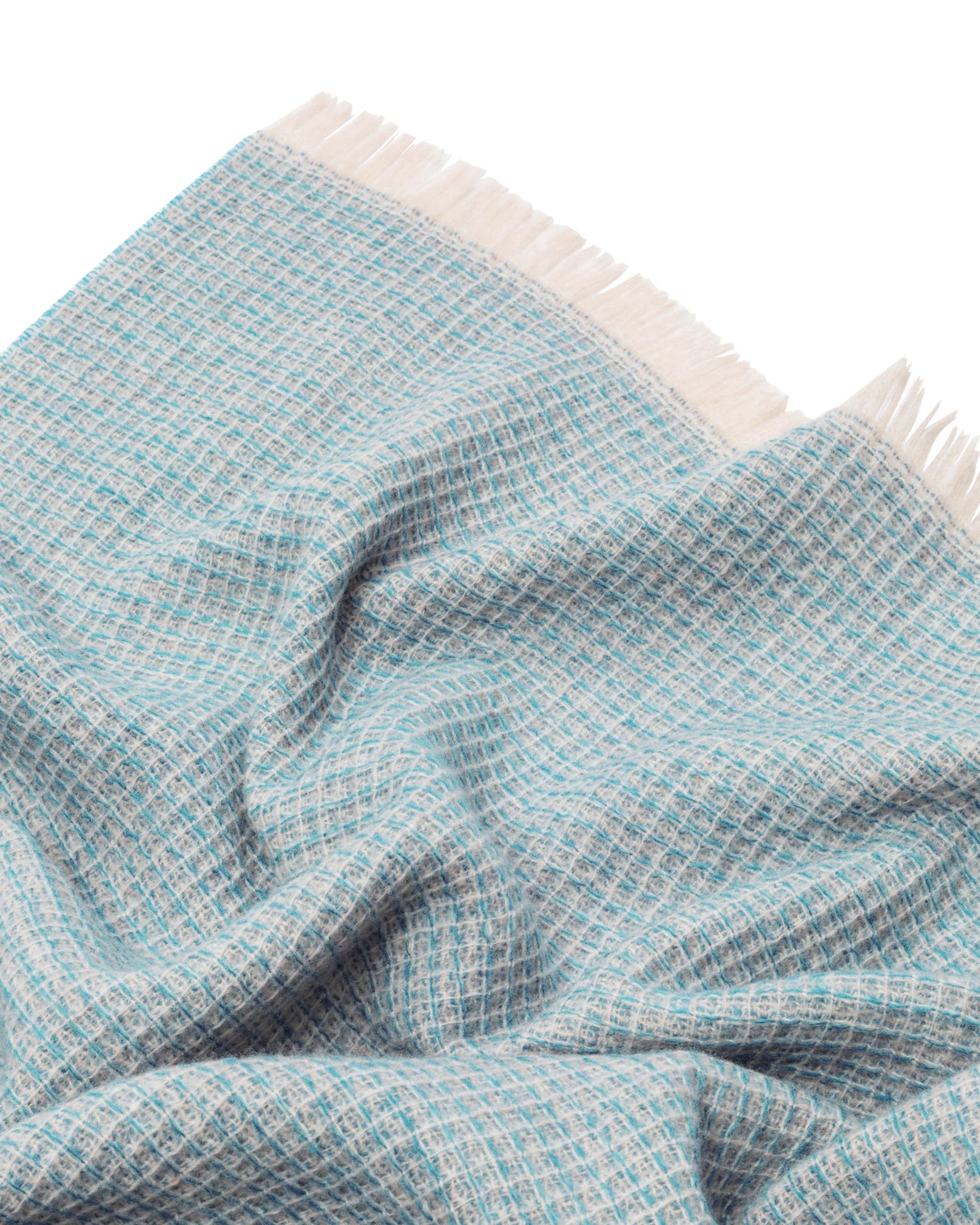 Close-up of Lanerossi Rossi Moon throw in aqua, showing open-weave texture and ivory fringe trim.