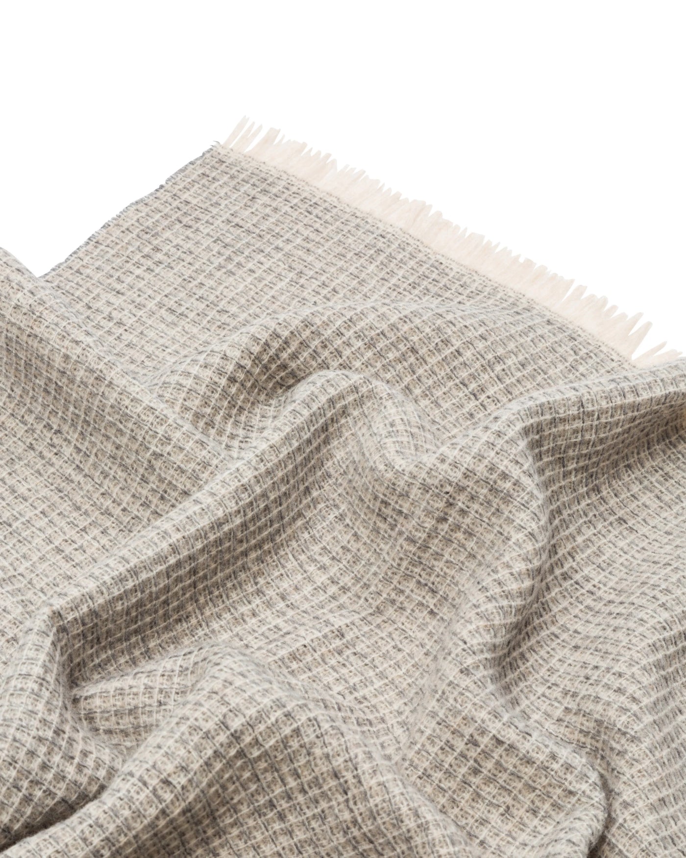 Ivory and grey waffle-weave throw with fringe trim, draped to show texture.