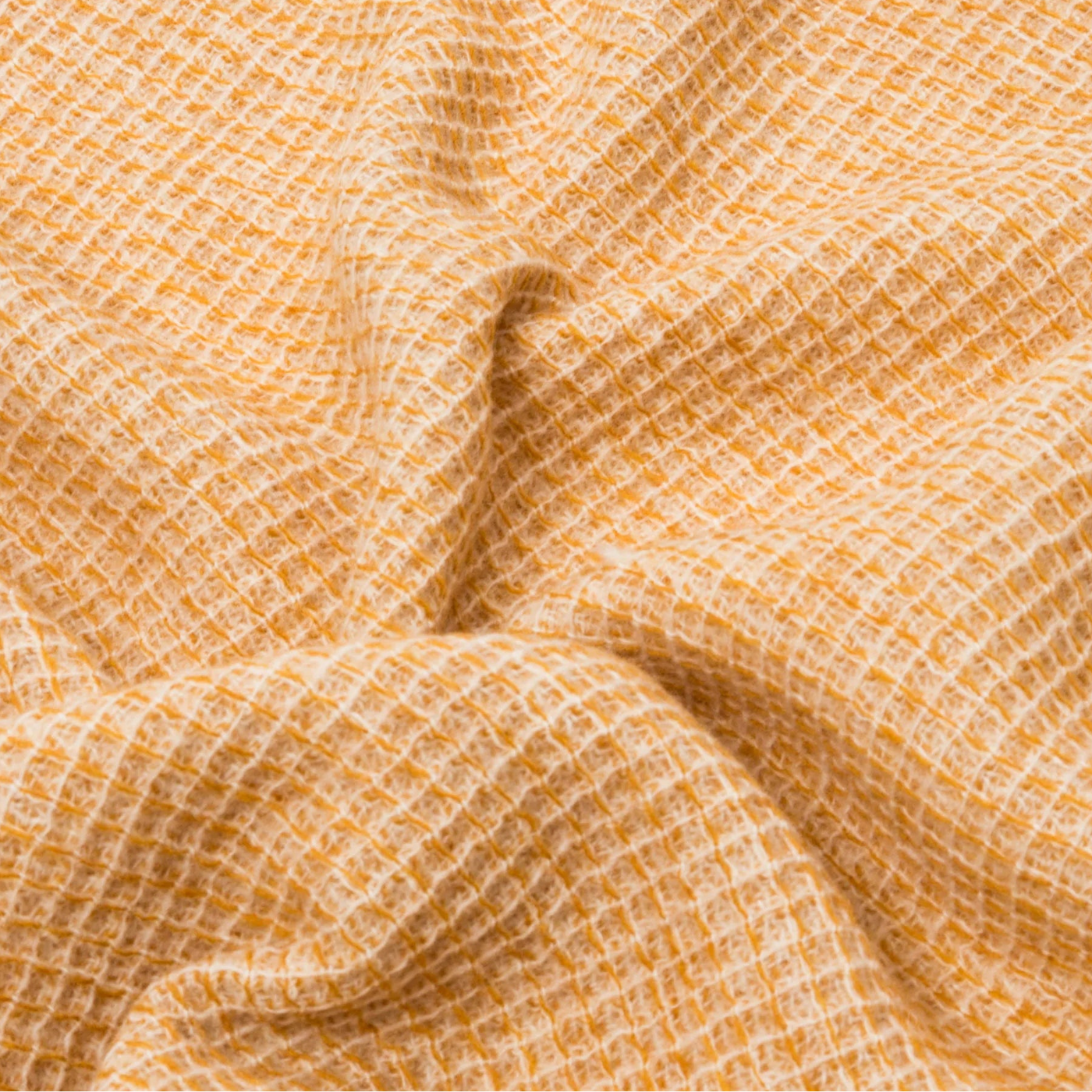 Close-up of Lanerossi Rossi Moon throw in saffron, showing open waffle-weave texture with soft draping.
