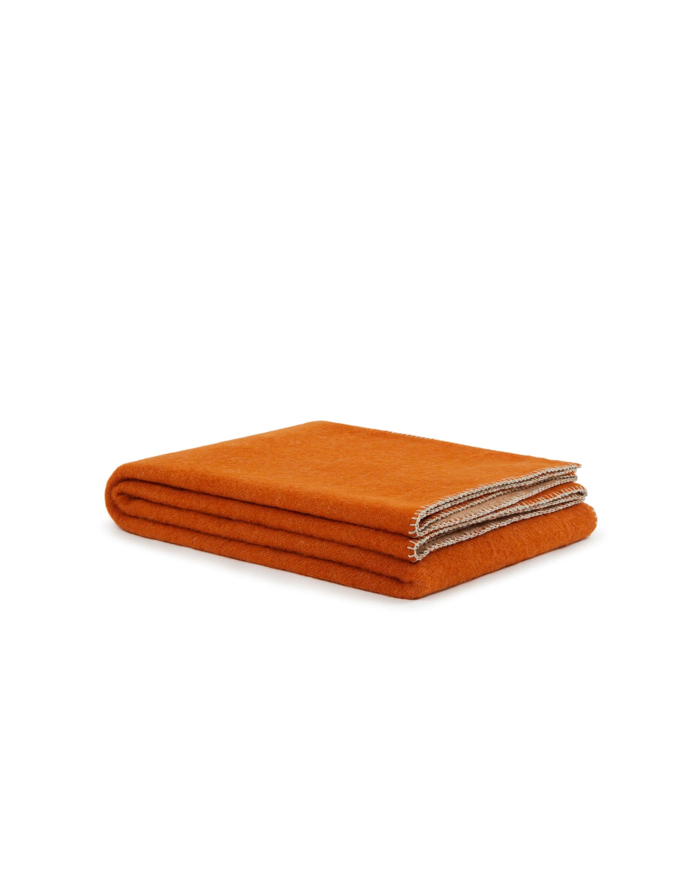 Folded Lanerossi Southland throw in burnt orange wool with contrast stitched edge detail.