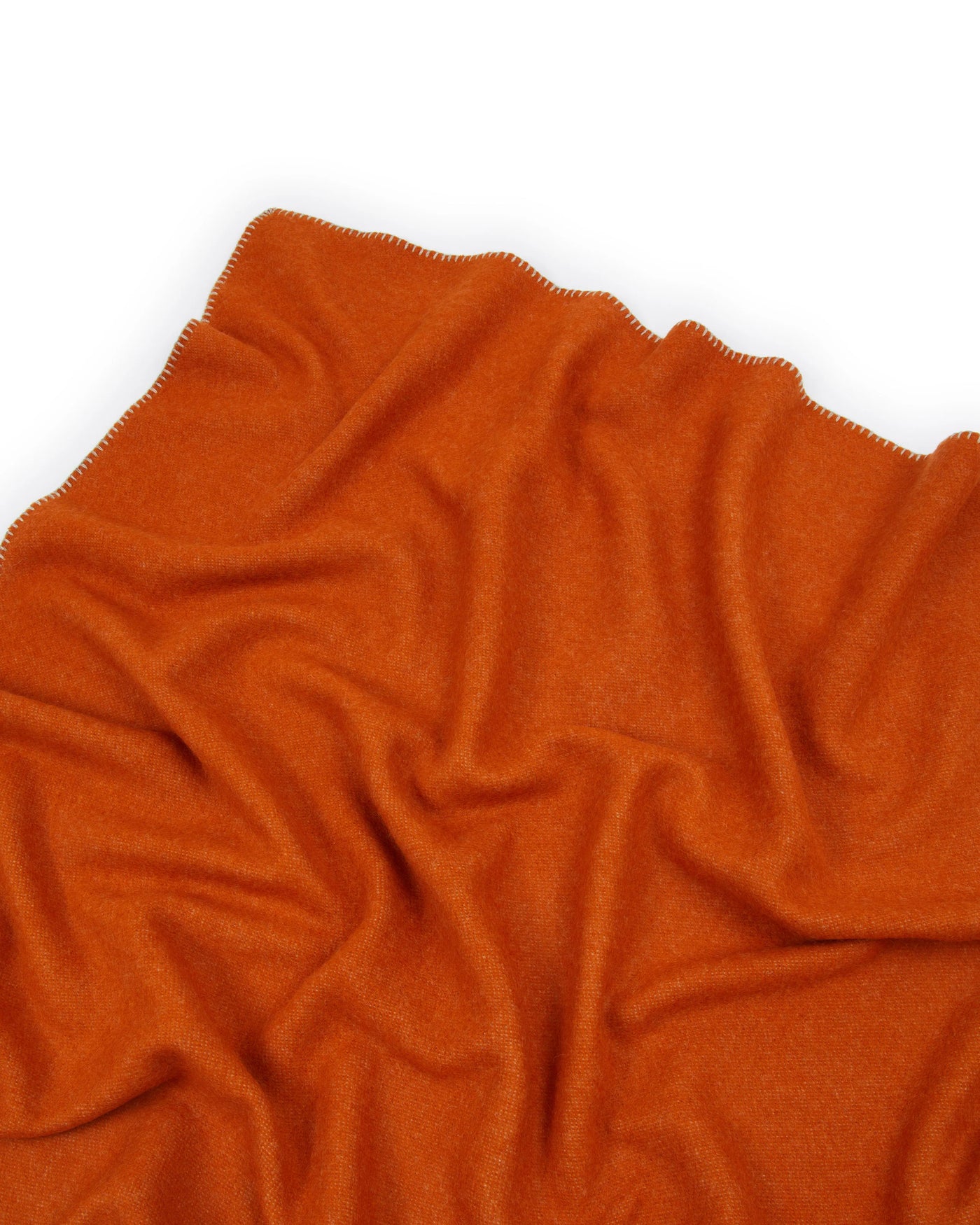 Close-up of Lanerossi Southland throw in burnt orange, showing blanket-stitched edge detail.