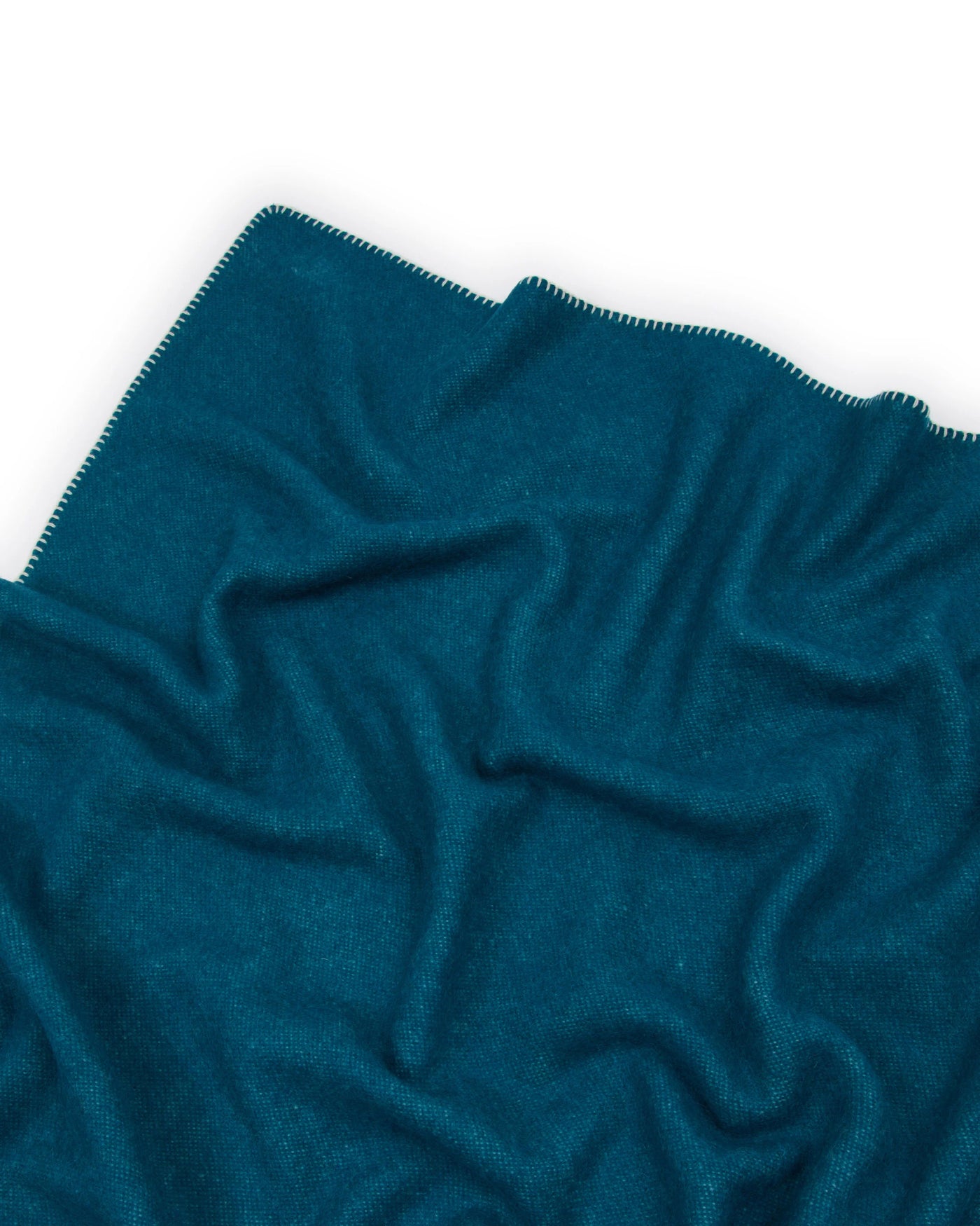 Lanerossi Southland throw in teal, draped to show blanket-stitched edge detail.