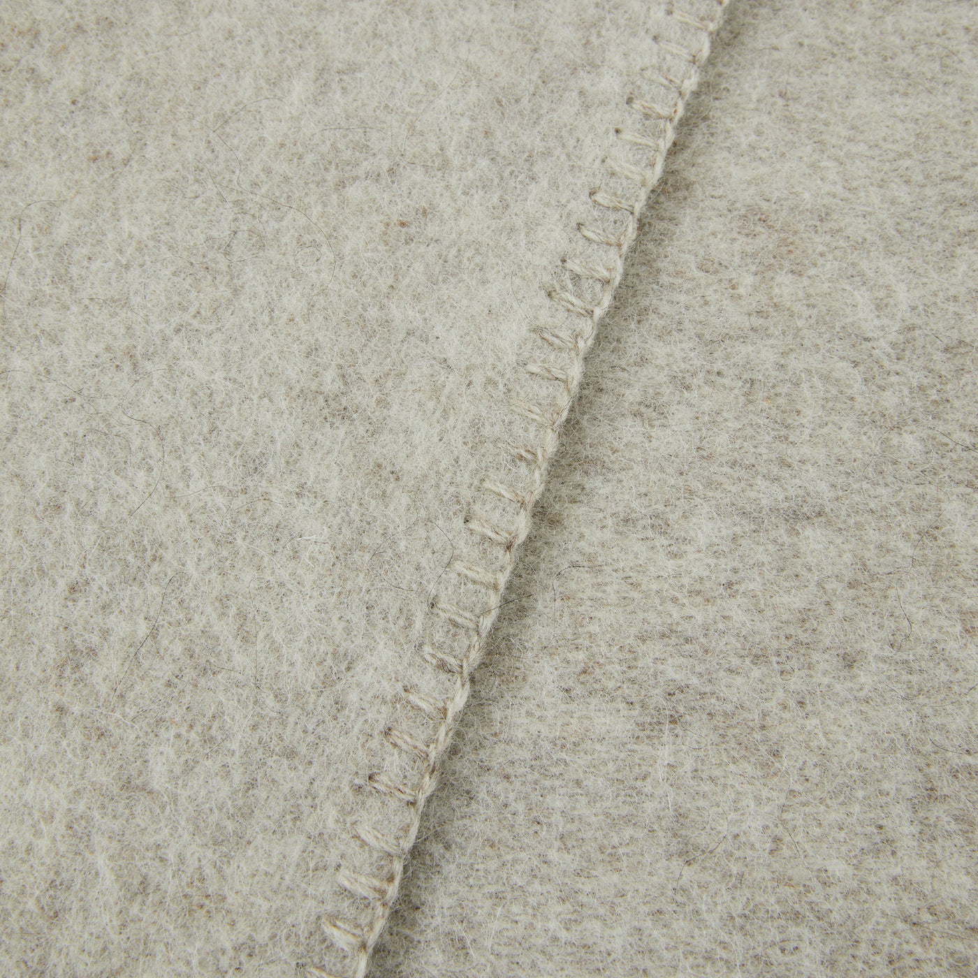 Close-up of Lanerossi Southland throw's blanket-stitched edge in oatmeal wool.