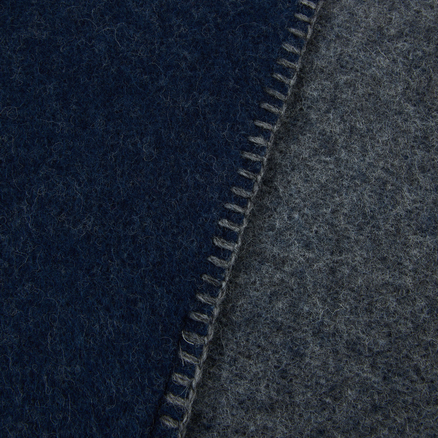 Close-up of blanket stitch edge joining navy and charcoal wool sides of Lanerossi Southland throw.