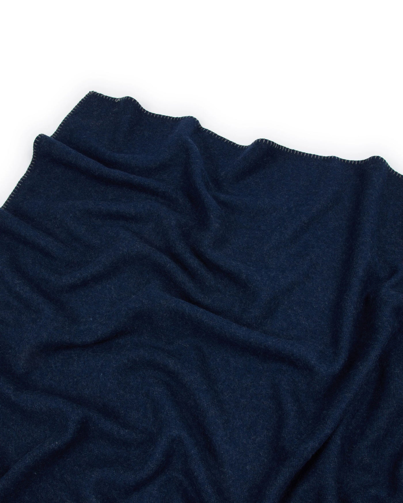 Navy knit throw with whipstitch edge detail, draped to show soft texture and gentle folds.