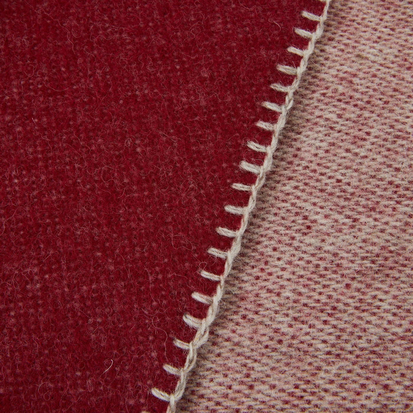 Close-up of Lanerossi Southland throw's whipstitch edge, crimson and blush reverse sides.