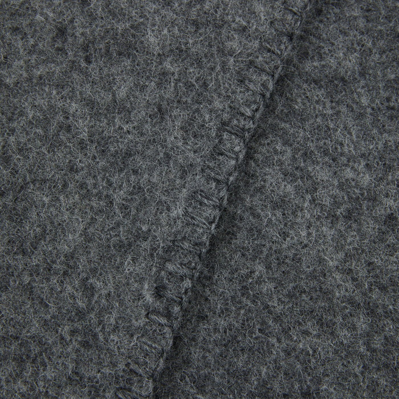 Close-up of Lanerossi Southland throw's fringed edge in charcoal wool blend fabric.