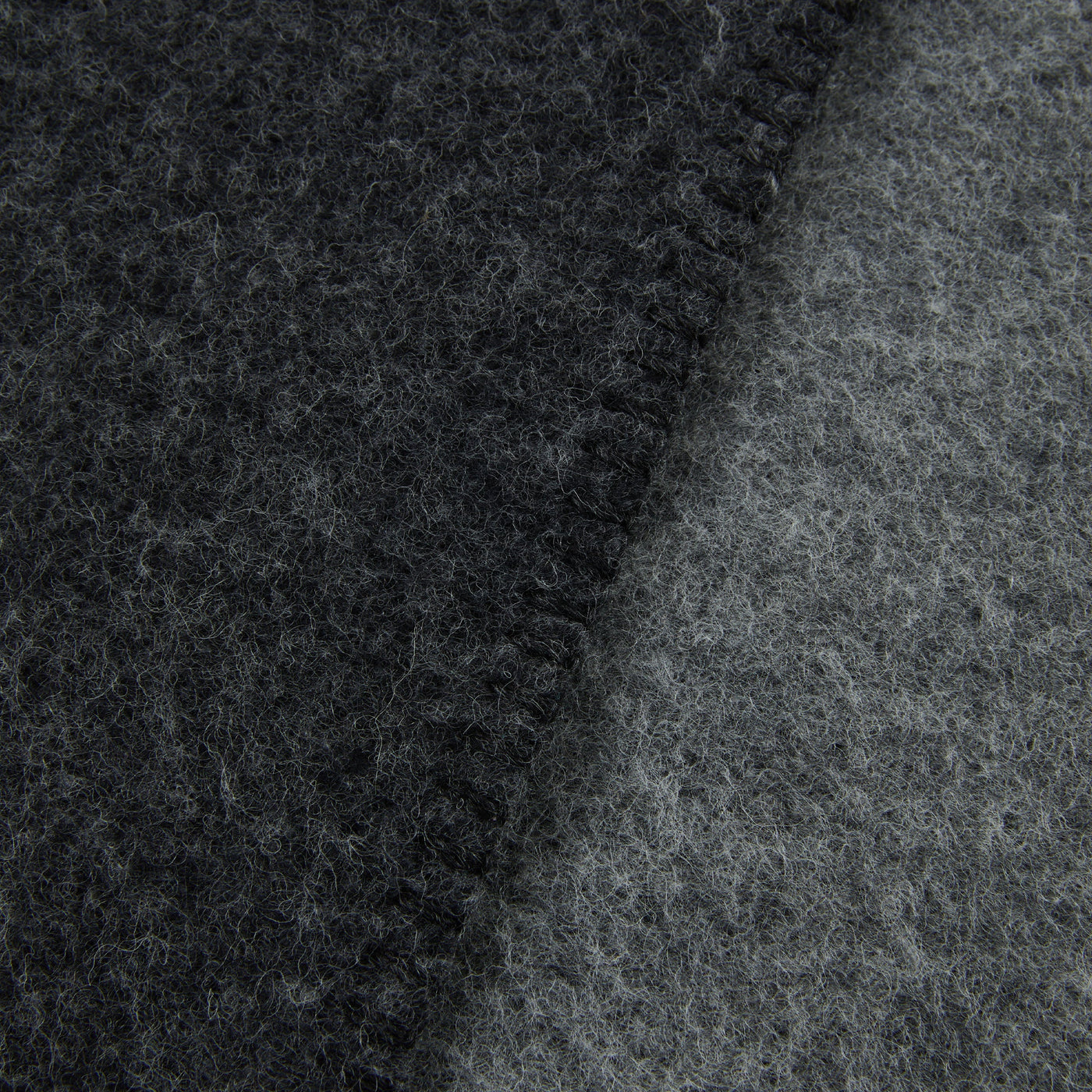 Close-up of Lanerossi Southland throw's charcoal boiled wool texture and stitched edge detail.
