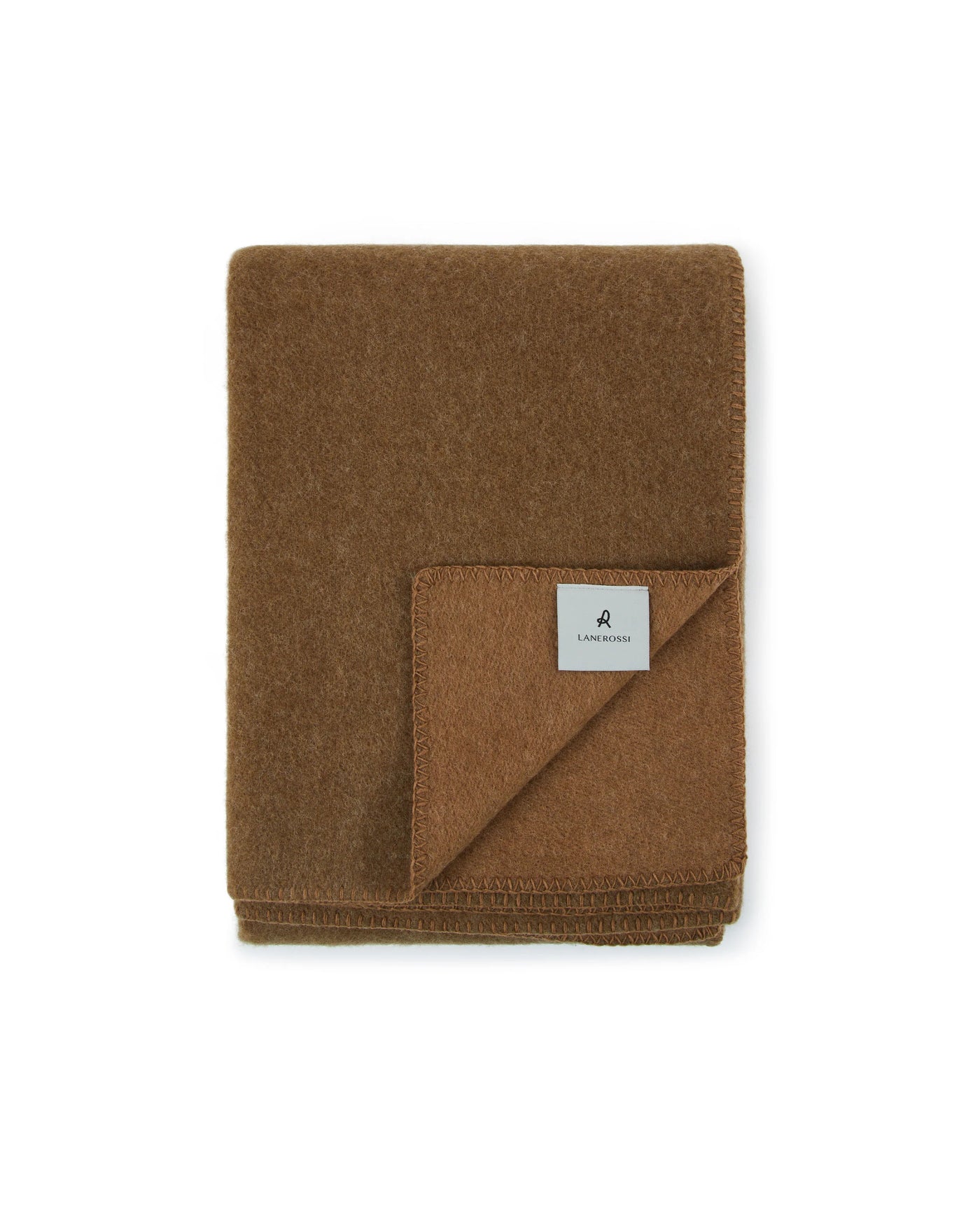 Folded camel wool throw with blanket-stitched edge and woven label, corner turned back.