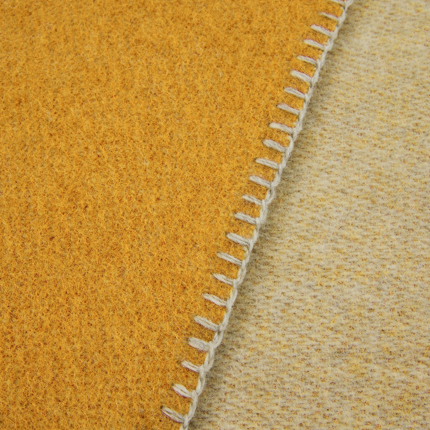 Close-up of Lanerossi Southland throw edge, showing mustard wool weave and cream blanket-stitch trim.