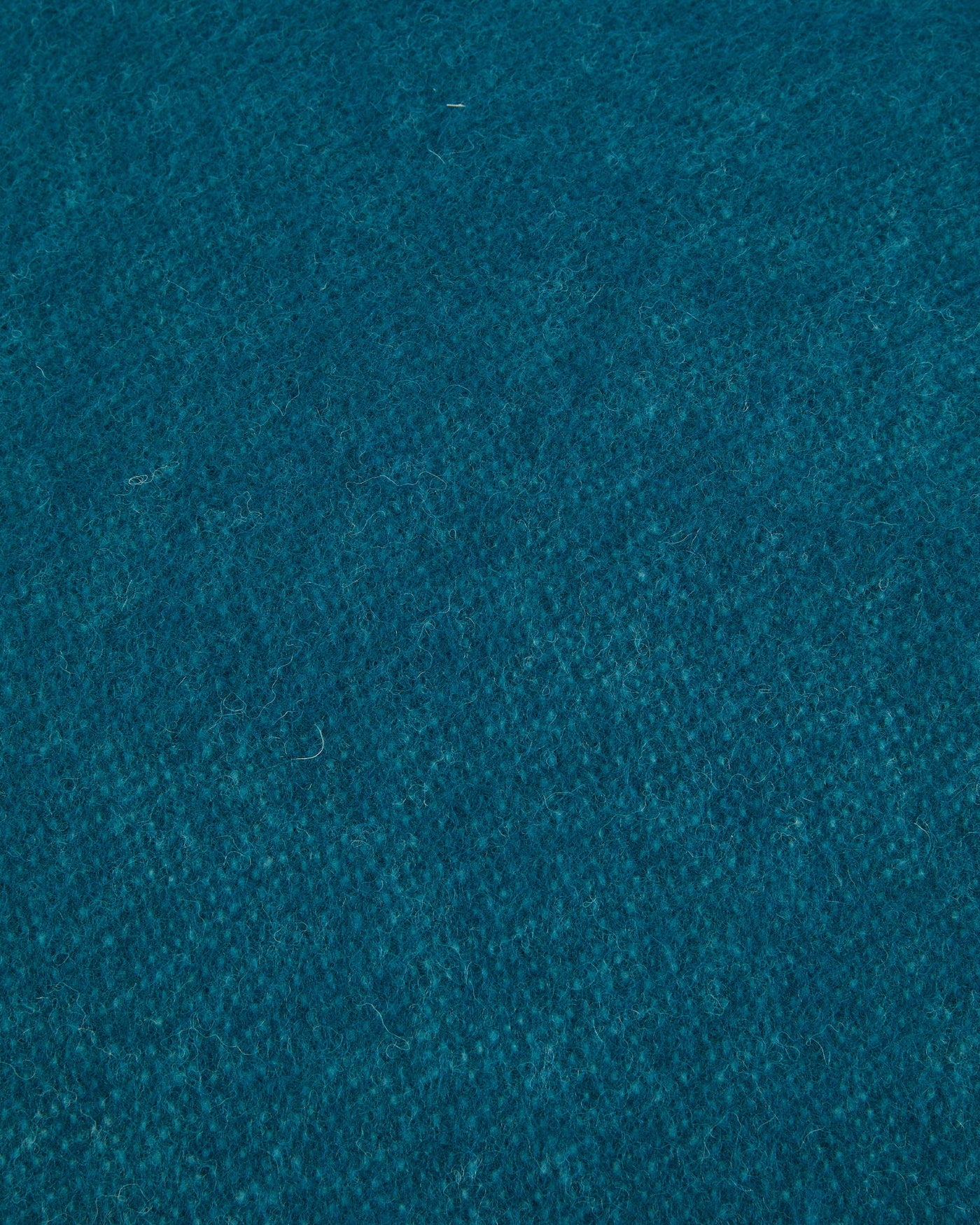 Close-up of teal wool fabric texture on a Lanerossi Southland cushion.