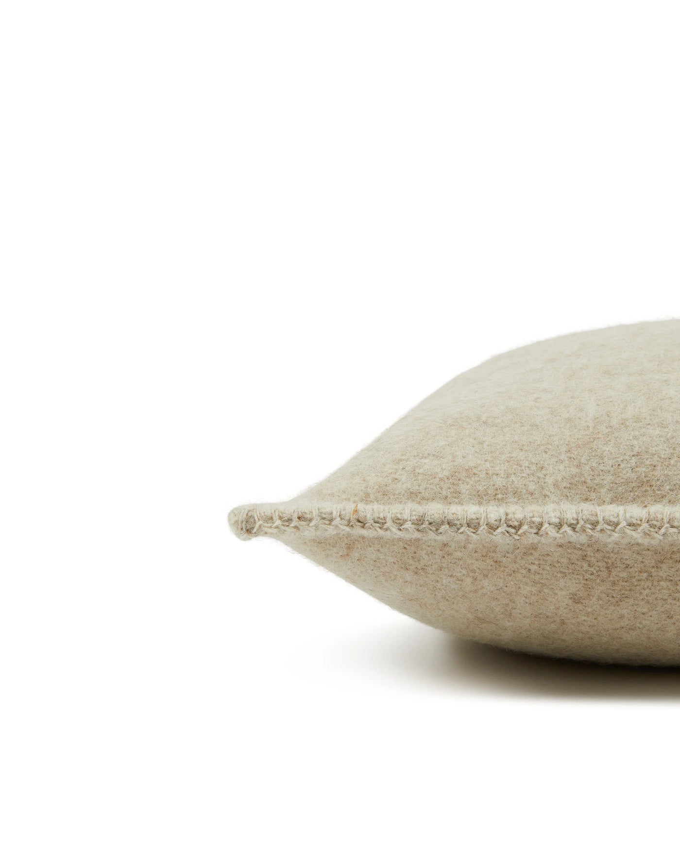 Close-up of Lanerossi Southland cushion edge showing blanket-stitch trim in natural oatmeal wool.
