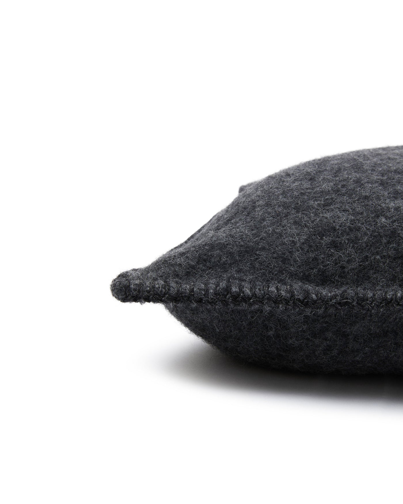 Close-up of Lanerossi Southland cushion corner in charcoal, showing blanket-stitch edge detail.
