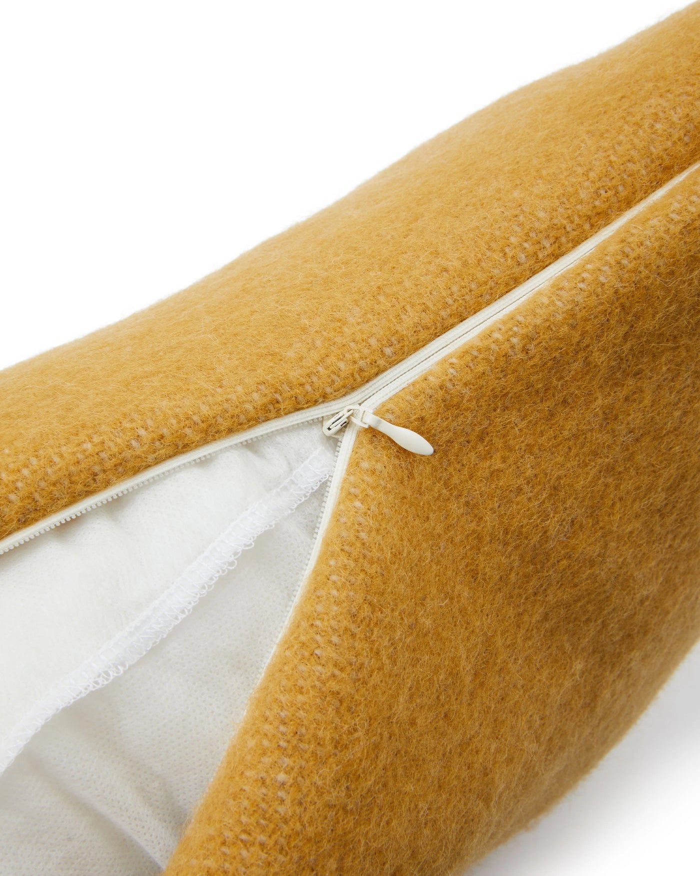 Close-up of Lanerossi Southland cushion zipper closure, mustard bouclé fabric, white lining visible.