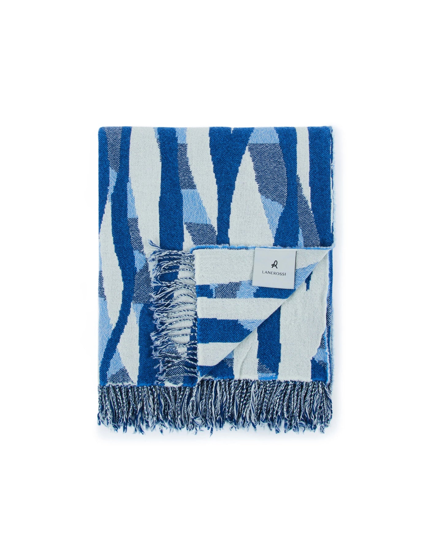 Folded Lanerossi Struttura throw in cobalt and pale blue abstract pattern with fringe trim.