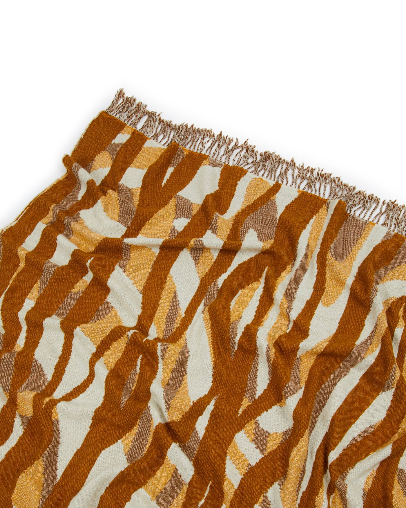 Close-up of Lanerossi Struttura throw corner, amber and ivory zebra pattern with fringe edge.