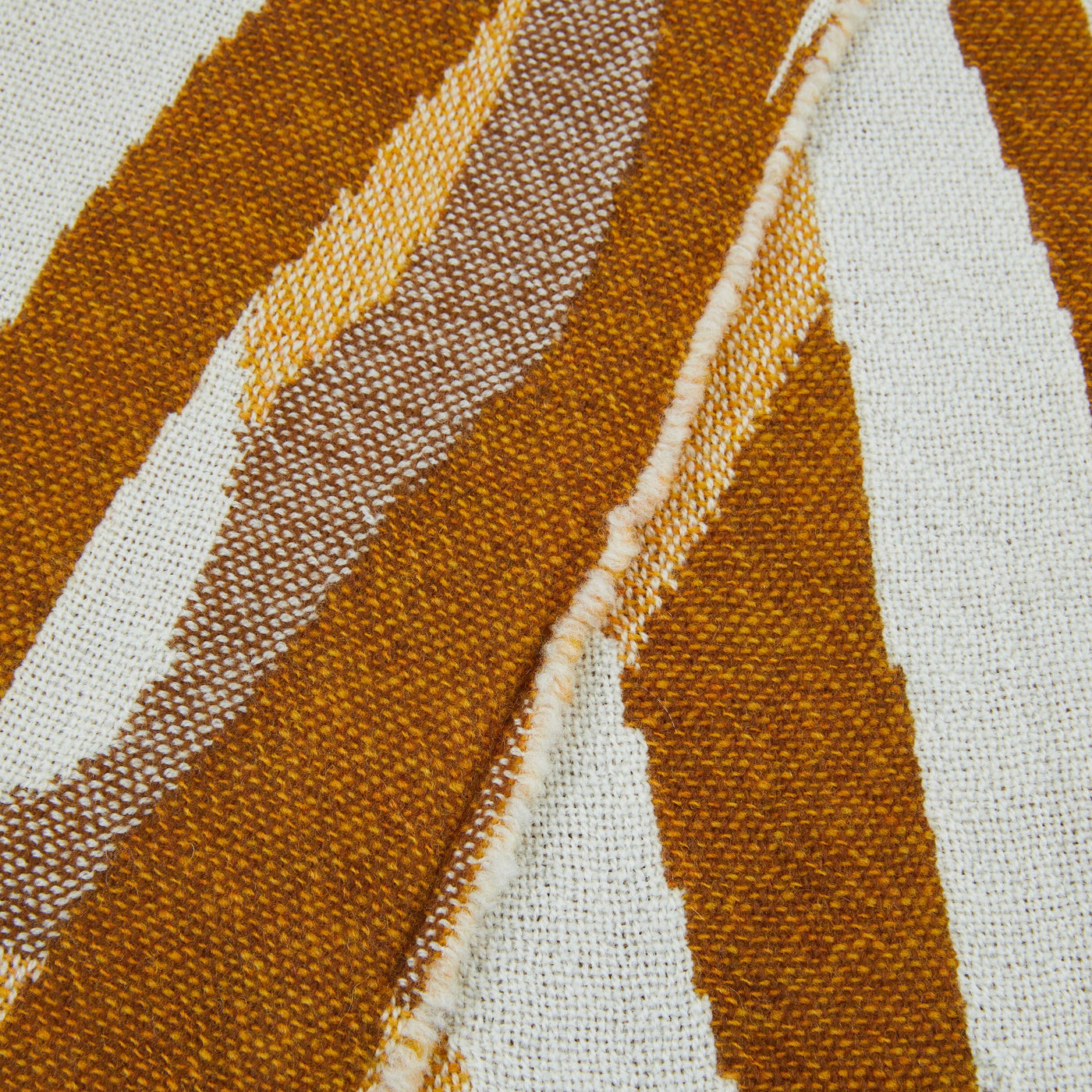 Close-up of Lanerossi Struttura throw weave in amber, ochre, and ivory diagonal stripes.