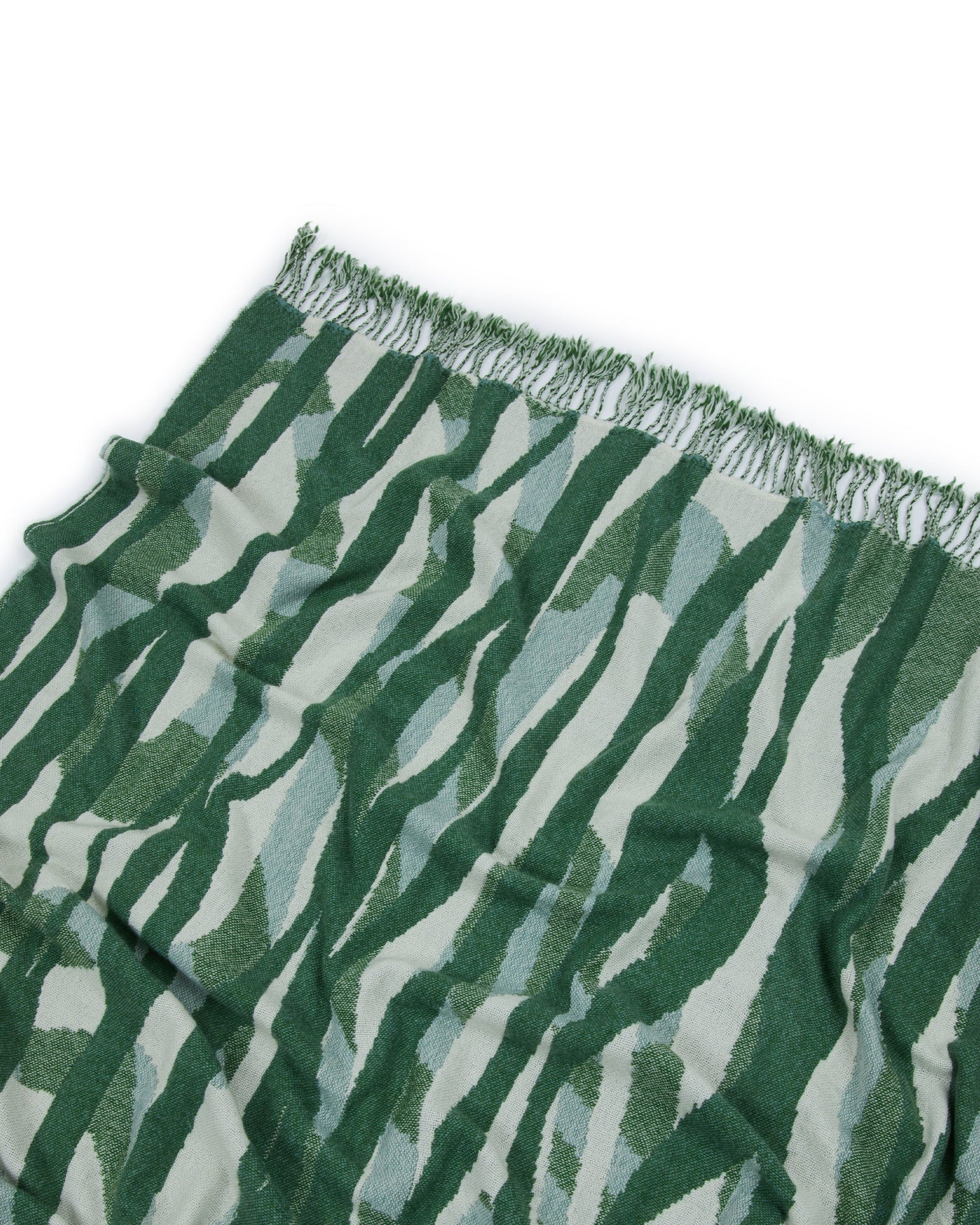 Close-up of Lanerossi Struttura throw fringe edge, forest green abstract wave pattern.