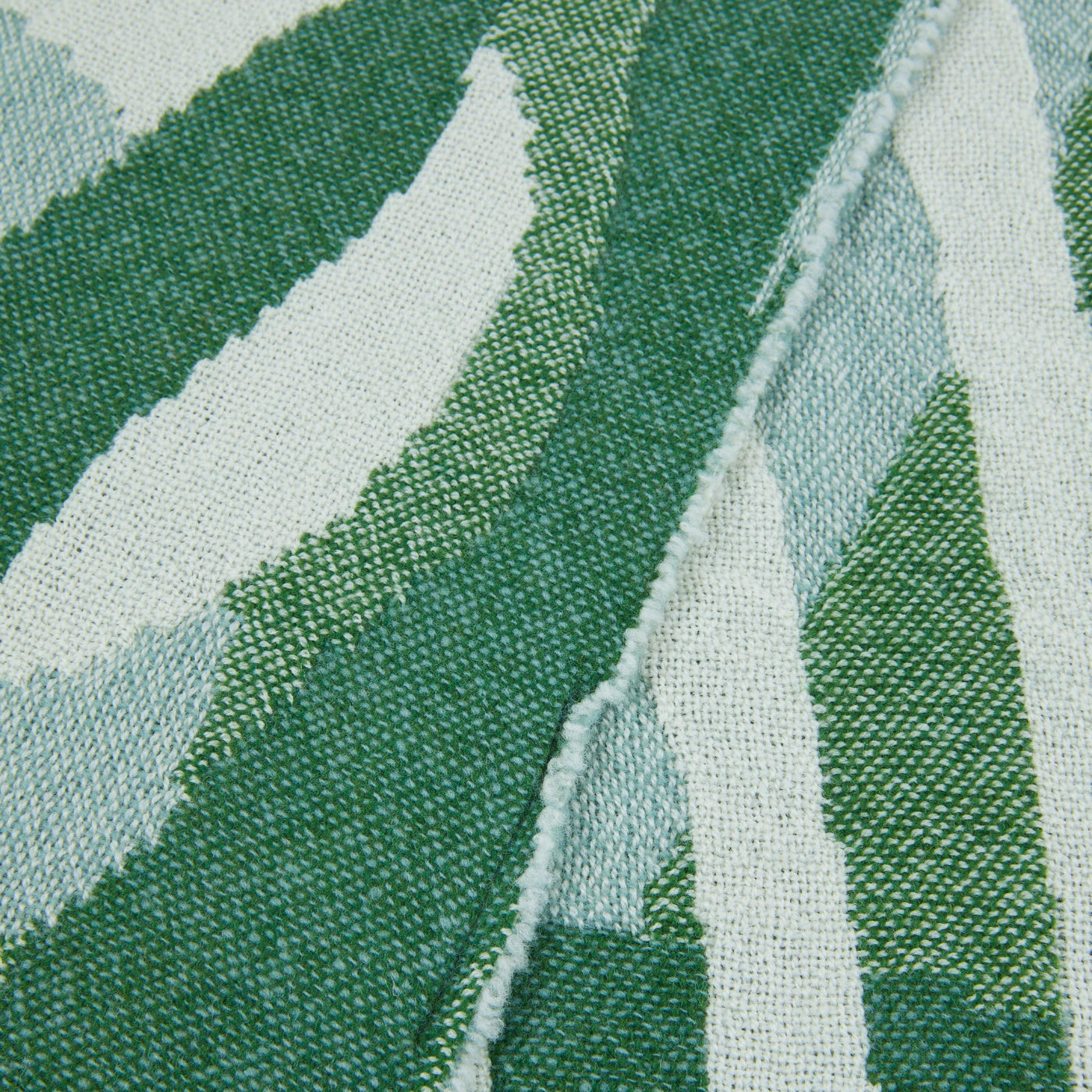 Close-up of Lanerossi Struttura throw weave, green and pale aqua leaf pattern.