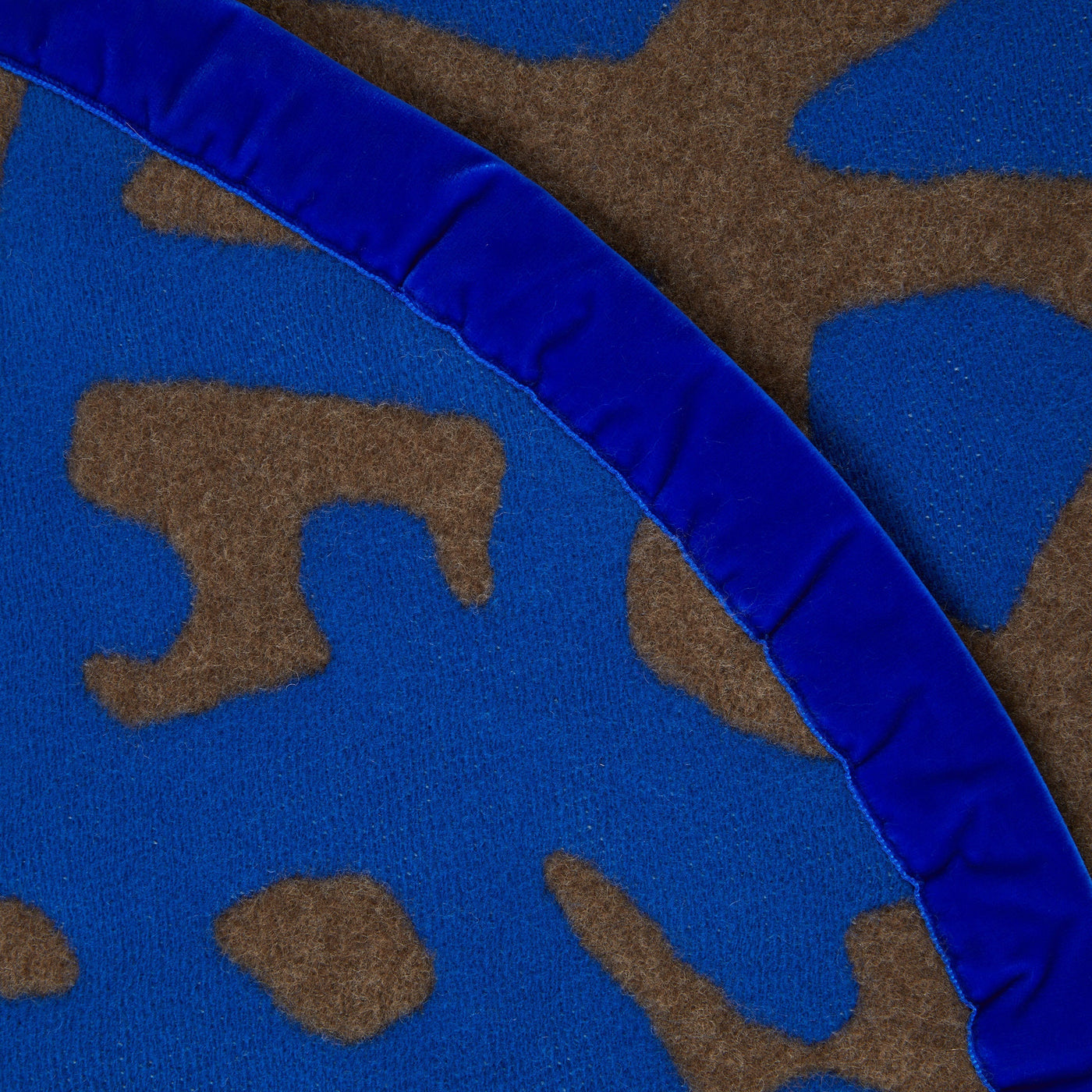 Close-up of Lanerossi Tribal blanket's cobalt blue satin ruffle trim edge detail.