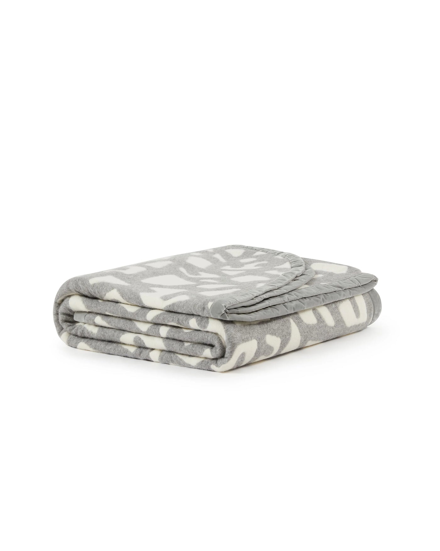 Lanerossi Tribal blanket folded, grey and ivory abstract motif pattern visible on top.