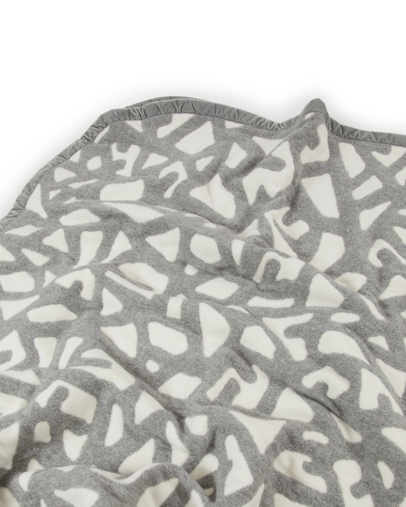 Close-up of Lanerossi Tribal blanket's grey and ivory abstract pattern with contrast trim.