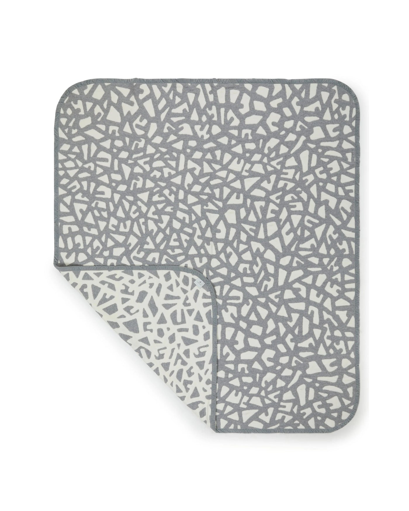 Lanerossi Tribal blanket corner folded back, revealing reversible slate and ivory mosaic pattern.