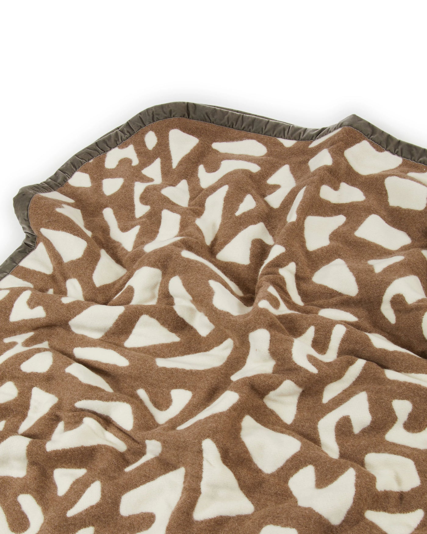 Close-up of Lanerossi Tribal blanket's abstract ivory and camel pattern with contrast blanket-stitched edge.