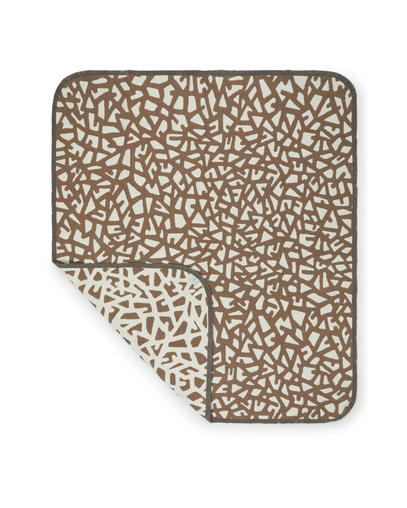 Lanerossi Tribal blanket corner folded back, revealing ivory reverse on taupe mosaic-print throw.