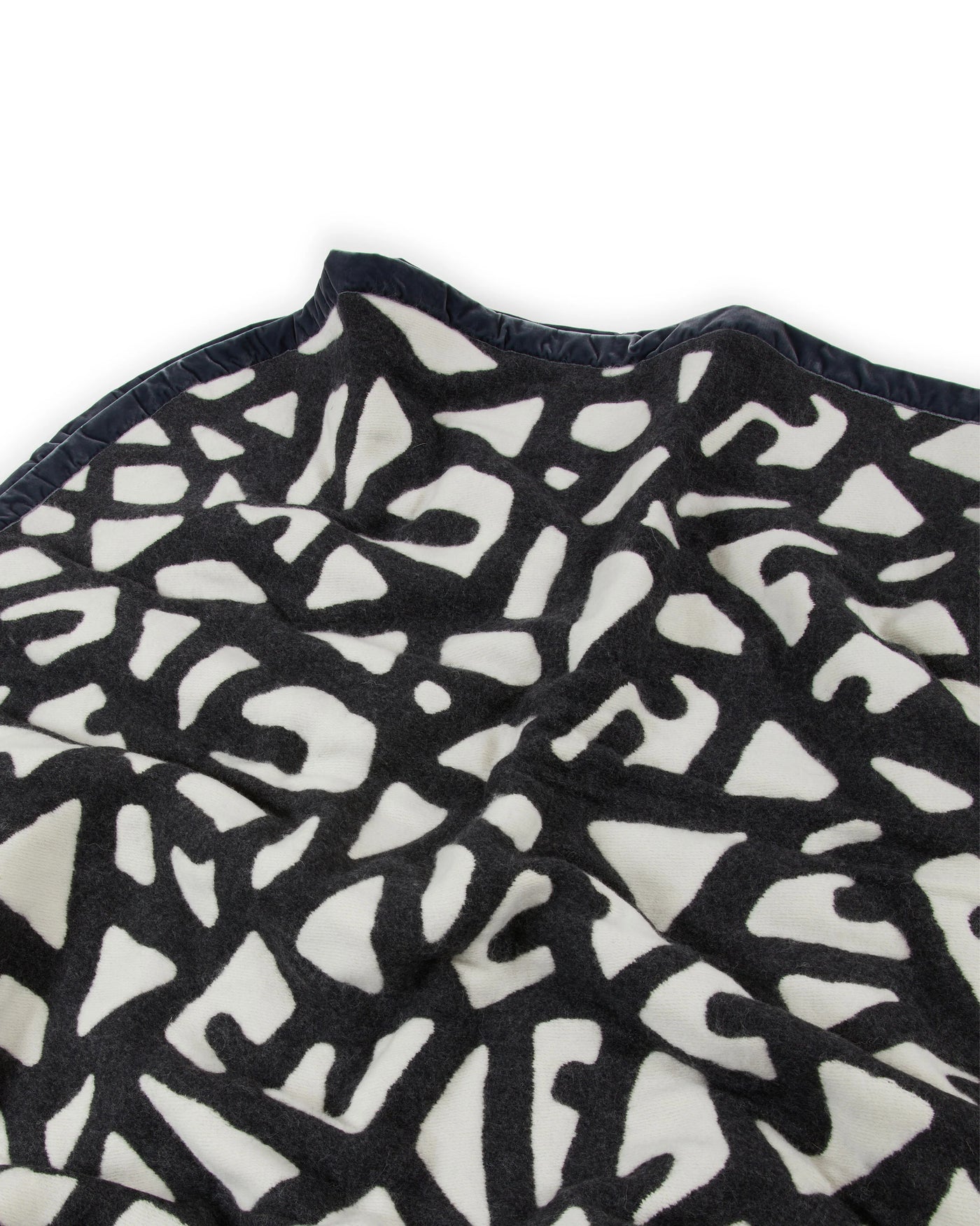 Close-up of Lanerossi Tribal blanket's black and ivory abstract cut-out pattern with navy trim detail.