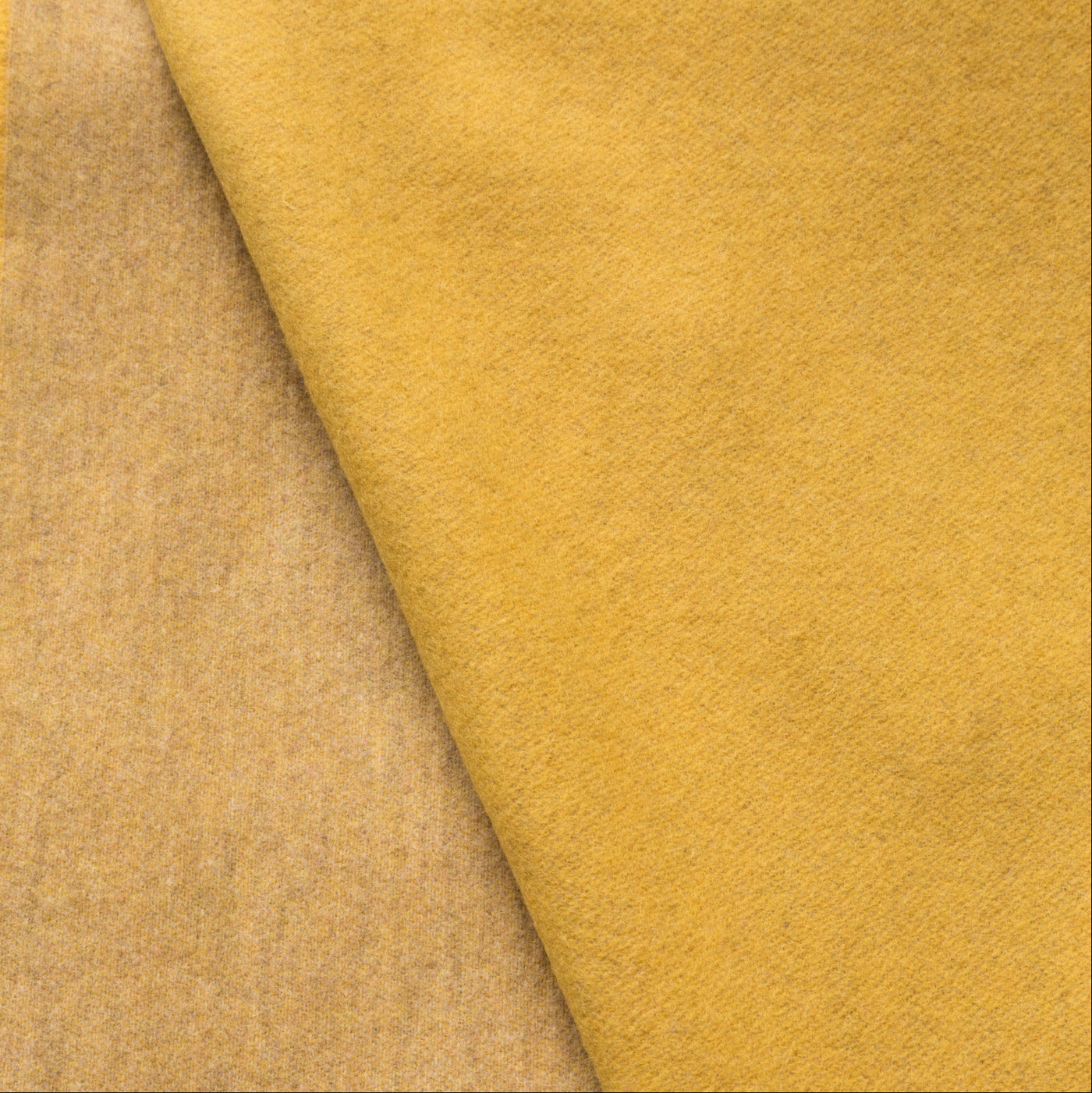 Close-up of folded saffron wool throw showing face and reverse fabric contrast.