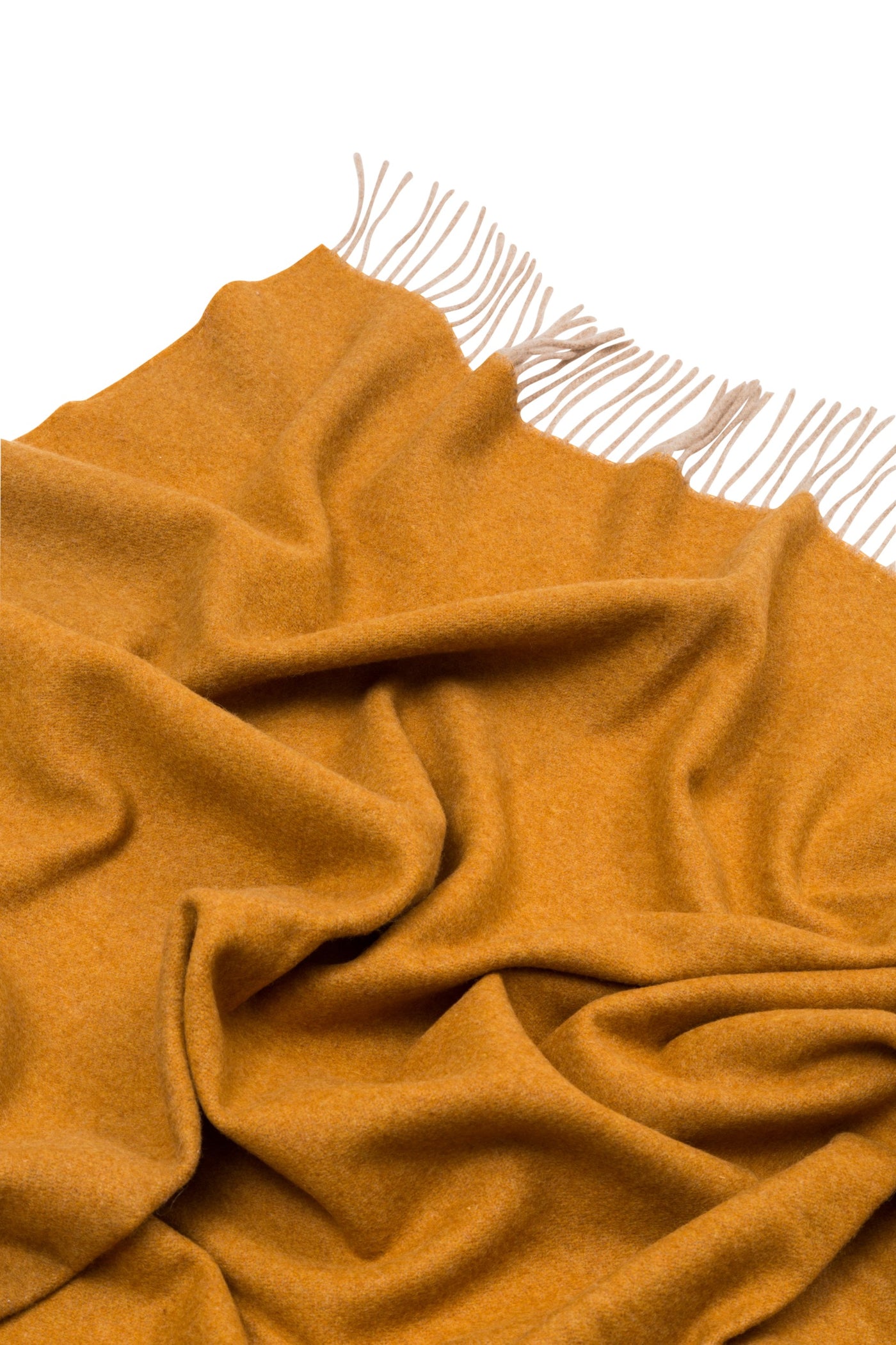 Saffron wool throw draped to show soft folds and cream fringe trim detail.