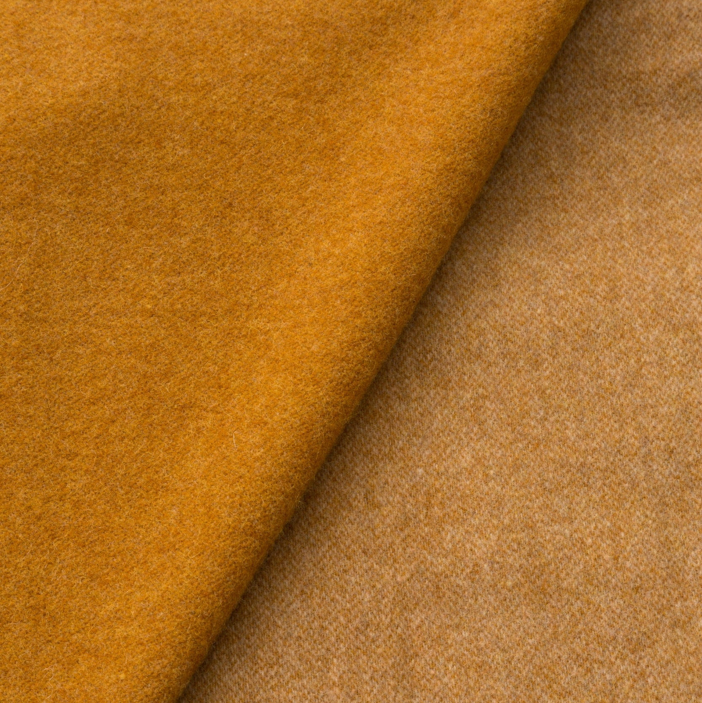 Close-up of Lanerossi Ulisse throw in amber, showing folded wool fabric texture.